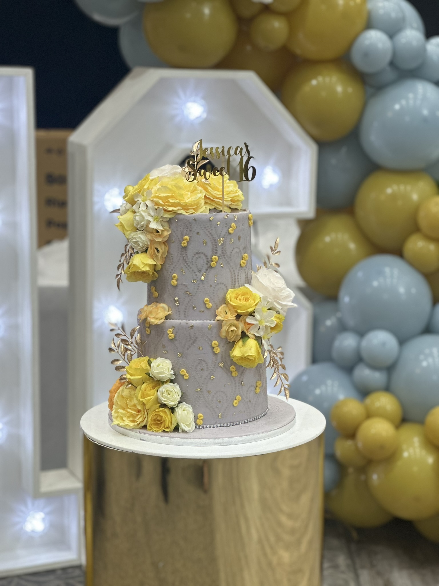 Jessica Sweet 16 grey and yellow floral cake at party