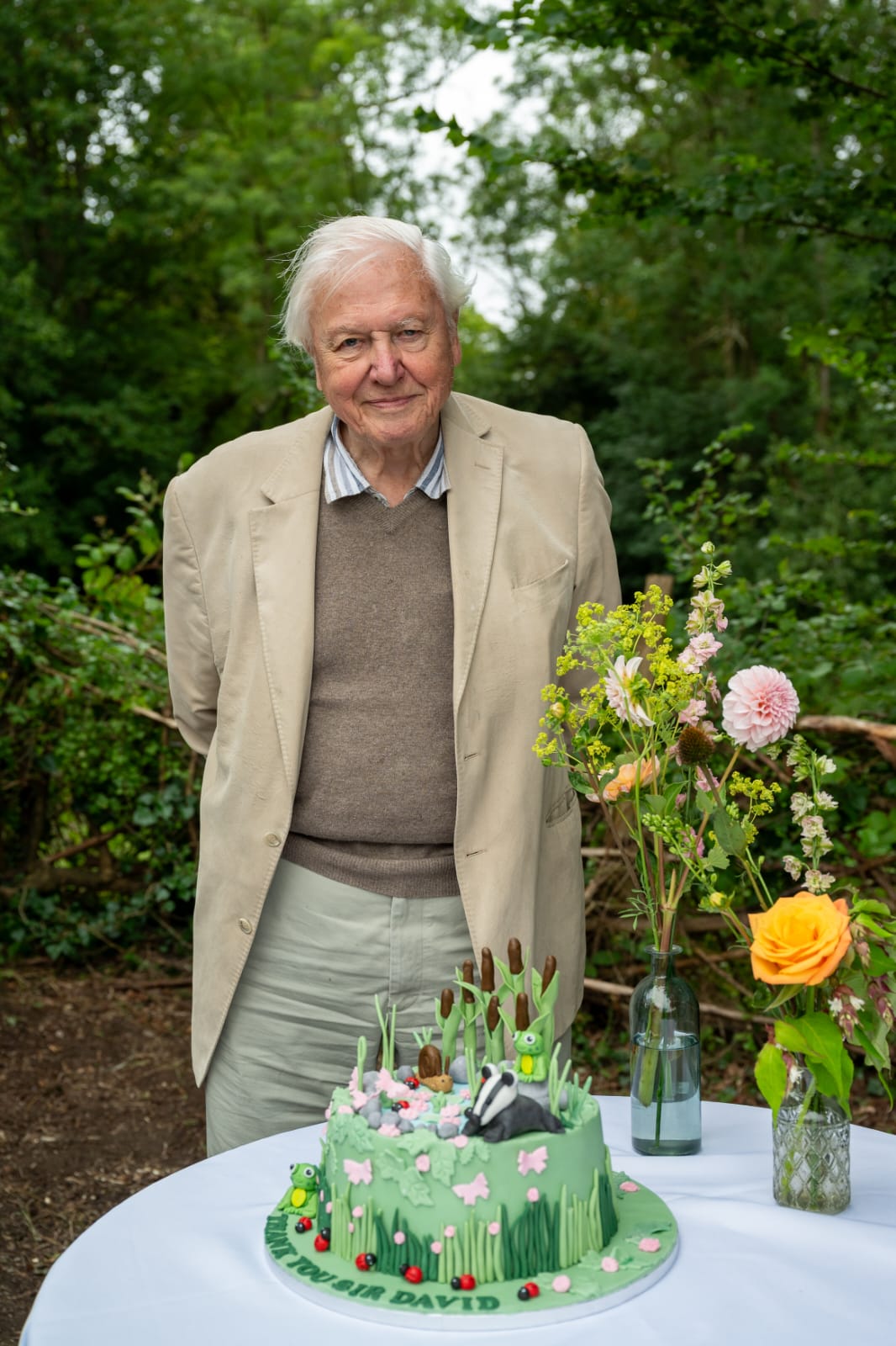Sir David Attenborough standing with the Thank You cake