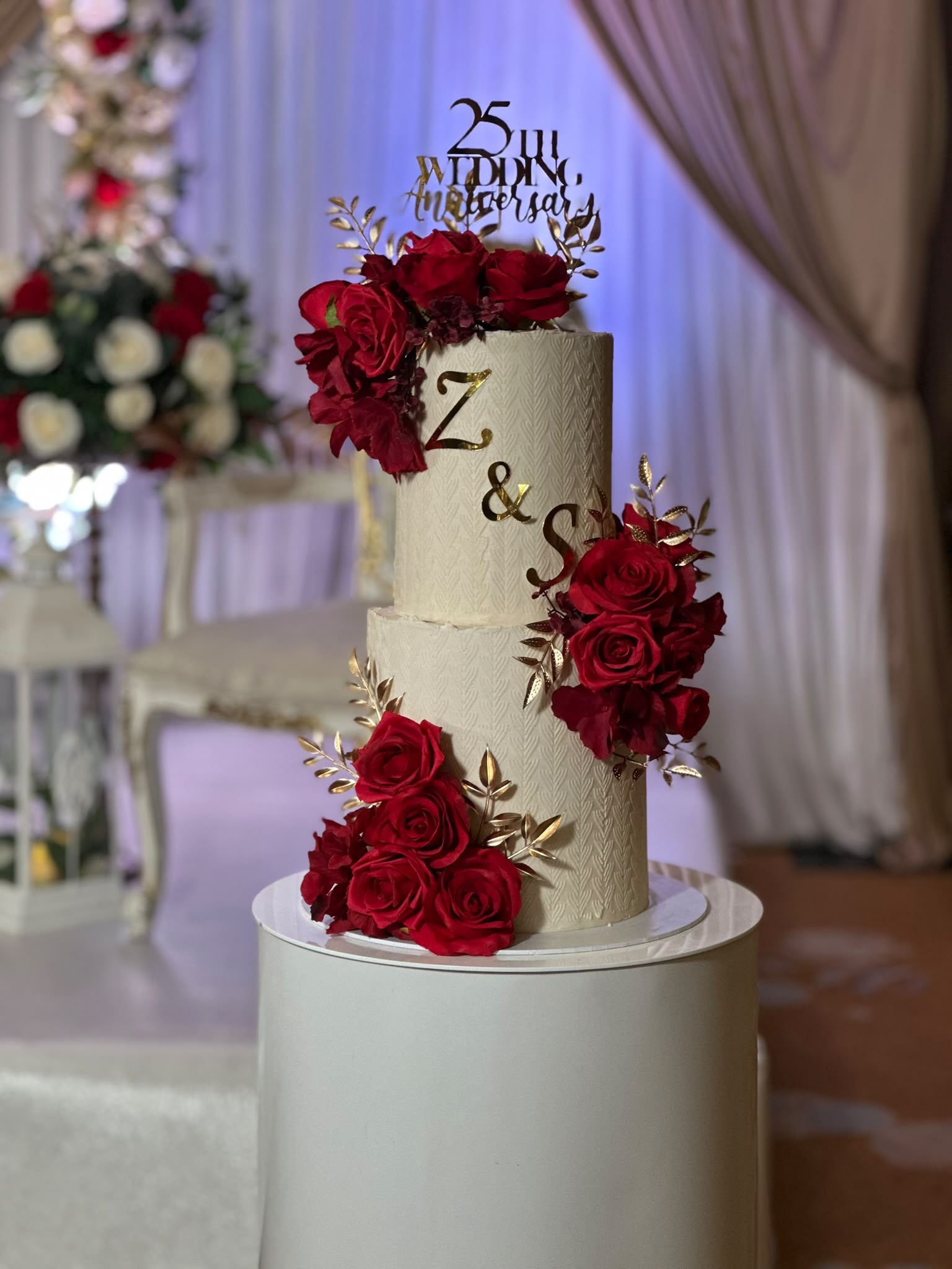 Wedding cake with red roses and gold monogram