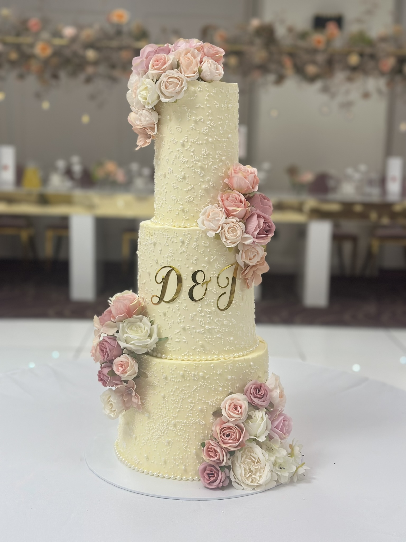 3 tier wedding cake with D&J gold initials and pink roses