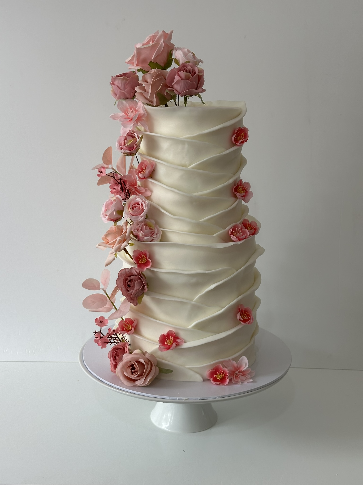4 tier ivory layered wedding cake with pink roses